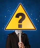 Businessperson holding yellow sign with question mark