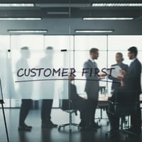 customer first on transparent wall in office with people in background