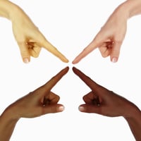Picture of 4 human hands of persons of different skin tones with index fingers sticking out and pointing at each other at right angles